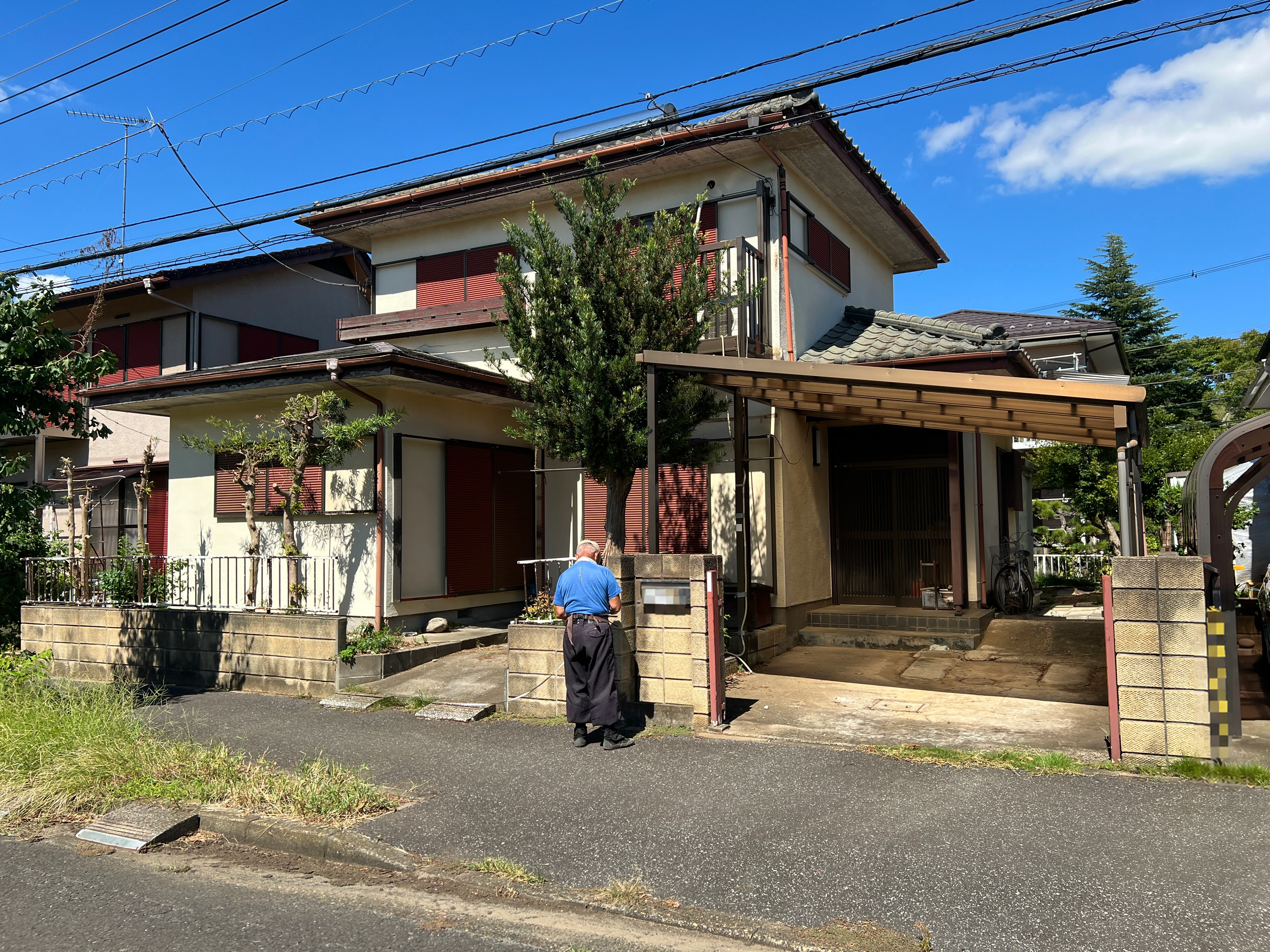 庭木とカーポートが残る改修前の建物外観