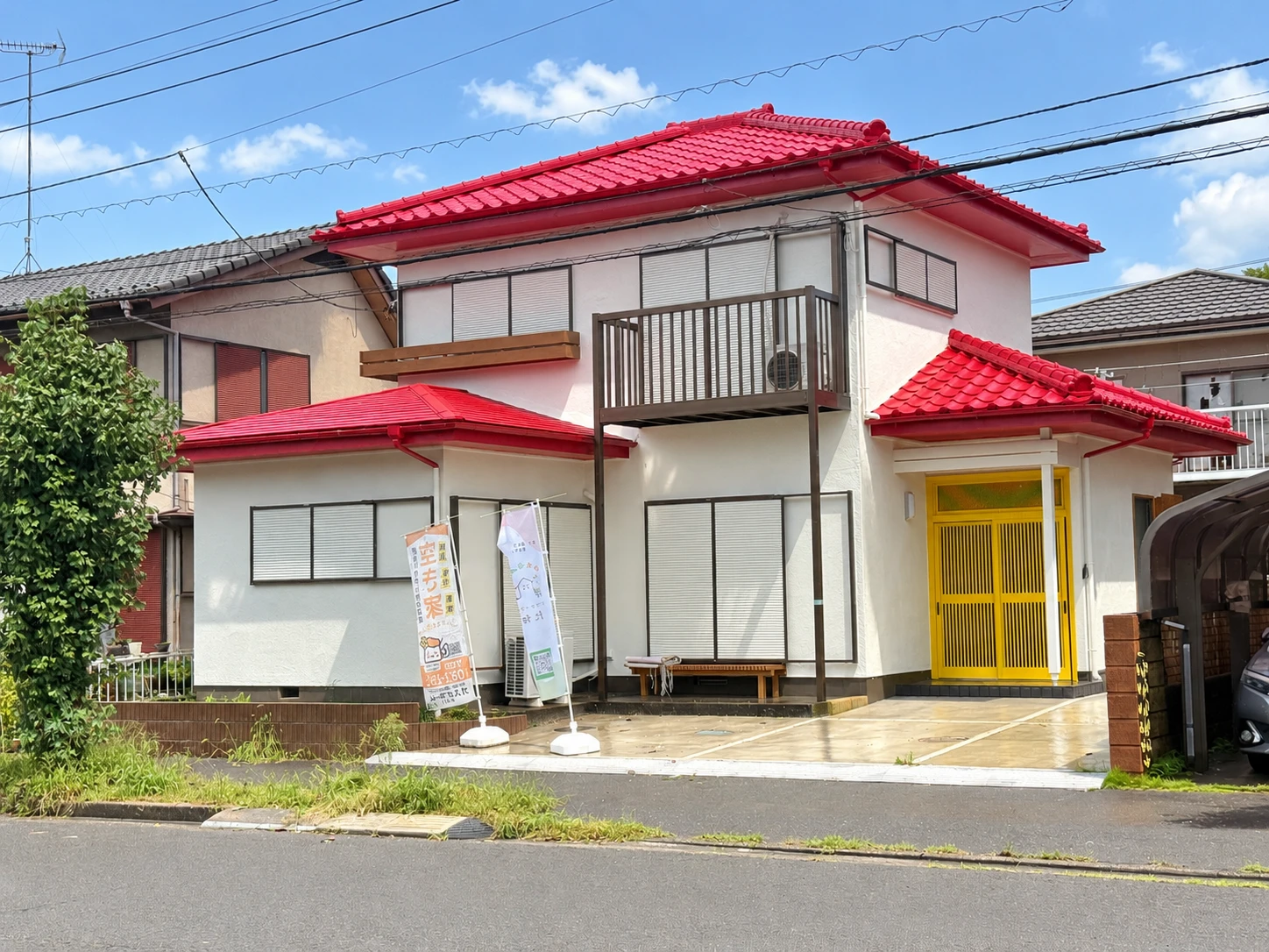 赤い屋根と黄色い玄関が目印のたねの外観